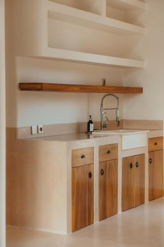 a kitchen with a sink and wooden cabinets at Green Waves Villa in Batukaras