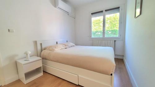 a white bedroom with a bed and a window at VILLA EN PROVENCE AVEC PISCINE AU CALME À ARLES - Camargue in Arles