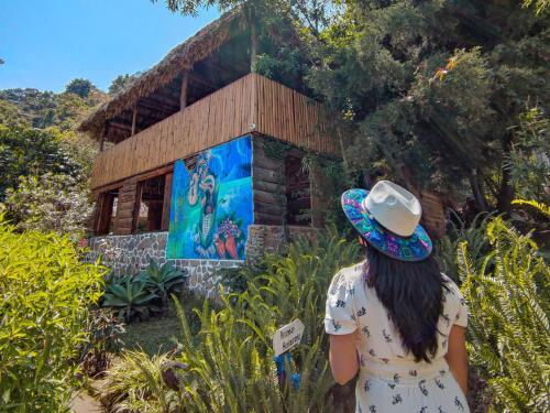 a woman in a hat standing in front of a building at Eco-Hotel Mayachik in San Juan La Laguna