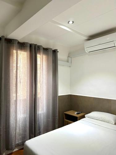 a bedroom with a bed and a window with curtains at Be Ramblas Guest House in Barcelona