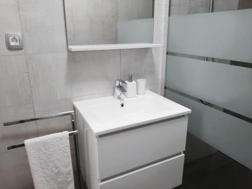 a white bathroom with a sink and a mirror at Apartma Dana in Jadranovo