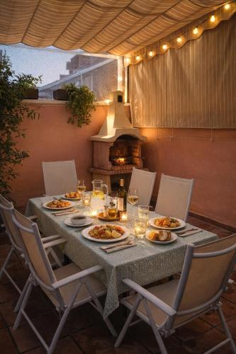 a table with plates of food on a patio at Casa familiar con patio privado y piscina comunitaria cerca de la playa in Málaga