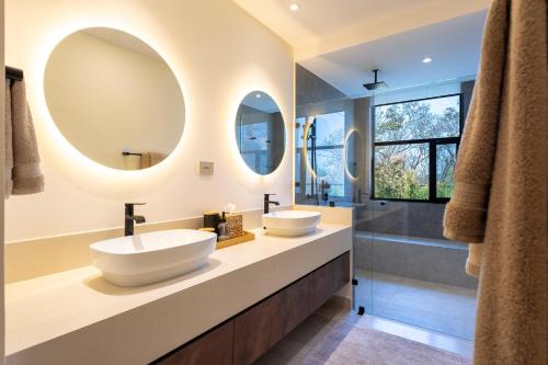 two sinks in a bathroom with two mirrors at 3101 - Paradise Cove 1A Violin in Tangolunda