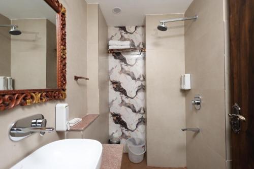 a bathroom with a sink and a mirror and a shower at Hotel Shringar Mahal Vrindavan in Chhatikara