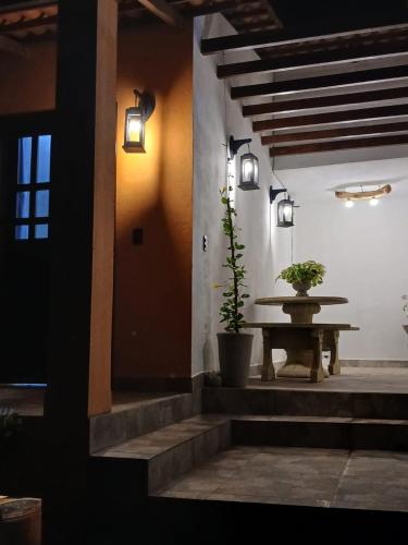 a room with a table and potted plants and lights at Chalés Flor de Mandacaru in Monte das Gameleiras
