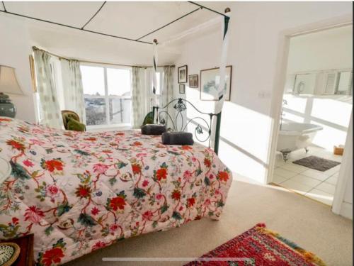 a bedroom with a bed and a bathroom with a tub at Rooms At Greystoke in Criccieth