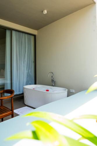 a bedroom with a bath tub and a bed at Petti Petti Beach Club- Mirissa in Mirissa
