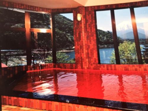 a pool in a house with a view of a mountain at Shoji Lake Hotel in Fujikawaguchiko