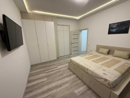 a bedroom with a large bed and white cabinets at Chirons Rest in Volos