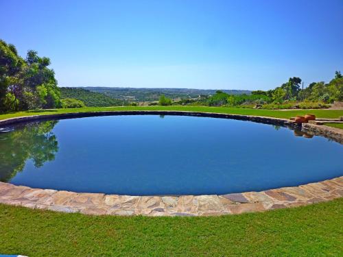 a large pool of water in a grassy field at Casa dos Sonhos, private terrace, quiet location, walking to village, ecological pool, pets considered, nature friendly in Barão de São João