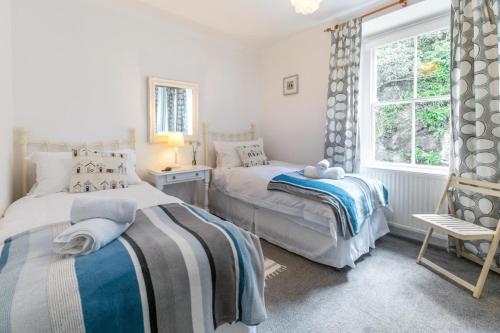 a bedroom with two beds and a window at 3 Bed in Porthleven oc-harbli in Porthleven