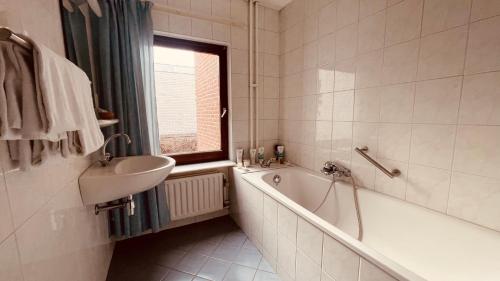 a bathroom with a tub and a sink and a bath tub at Hotel Heynen in Valkenburg
