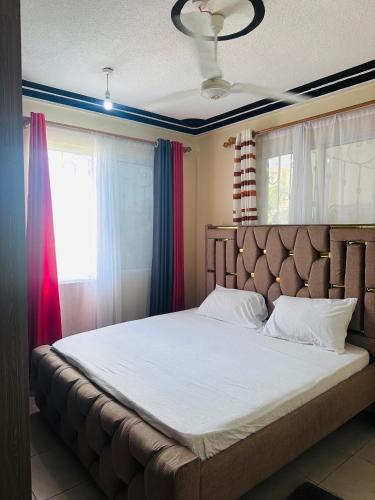 a bedroom with a large bed in front of a window at Honed homes in Mombasa
