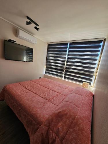 a bedroom with a large red bed and a window at Apartamento Los Andes II in Los Andes
