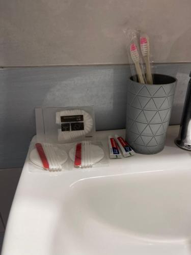 a bathroom counter with a sink and toothbrushes at Little himara 1 in Himare