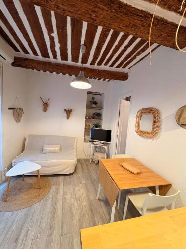 a living room with a bed and a table at Cassis et ses trésors in Cassis