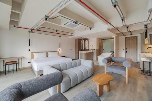 a living room with a white couch and a bed at Lomm By Somos The Group in Medellín