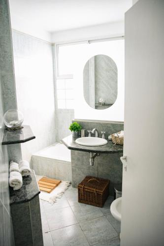 a bathroom with a tub and a sink and a mirror at AMADO-Un sueño in Junín