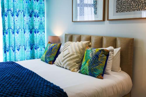 a bed with pillows on it in a room at Luxury 1BR Seafront Apartment in Cardiff