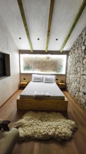 a bedroom with a bed and a stone wall at Stone House Montenegro in Danilovgrad