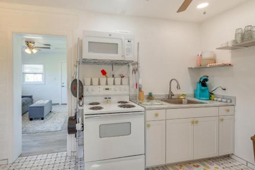 a kitchen with a white stove and a microwave at Route 66 Roadtripper Retreat w/ Private Backyard in Kingman