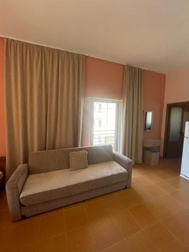 a couch sitting in a living room with a window at Bleta Residence in Sarandë
