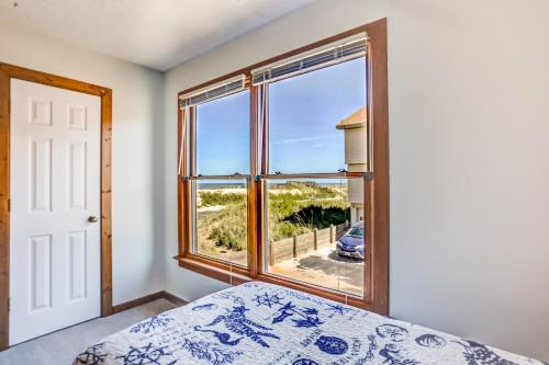 a bedroom with a bed and a large window at Ocean Views From Every Room in Kitty Hawk