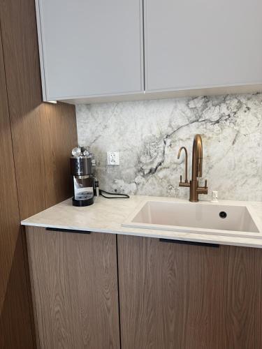 a kitchen counter with a sink and a coffee maker at Casella Apartment E34 Let's Sea Baltic Park in Gąski