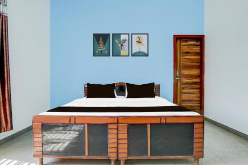 a bed in a room with a blue wall at Hotel O KLER Guest House in Kharar