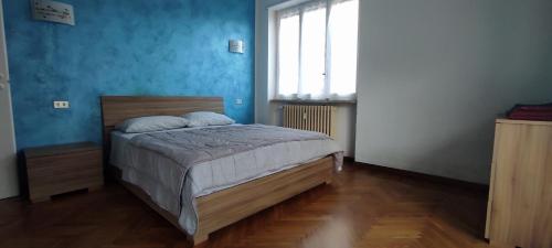 a bedroom with a bed with blue walls and a window at Alloggio Tommy in Biella