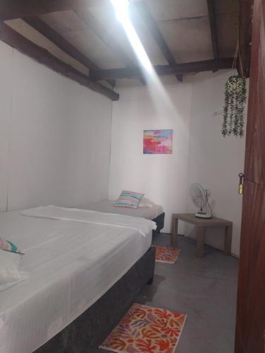 a bedroom with two beds and a table with a fan at Pikua Beach Baru in Playa Blanca