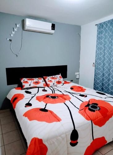 a bedroom with a bed with red flowers on it at Tu hogar ideal, cómodo, acogedor y único in Los Mochis