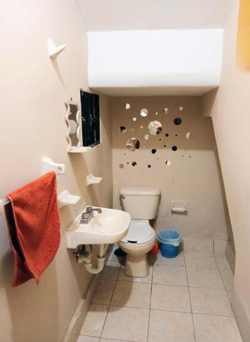 a bathroom with a toilet and a sink at Tu hogar ideal, cómodo, acogedor y único in Los Mochis