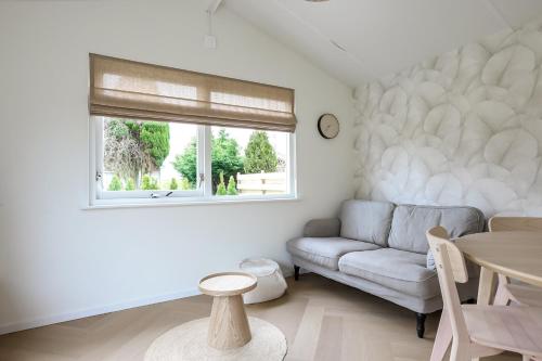 a living room with a couch and a window at Rekerlanden 270 in Warmenhuizen