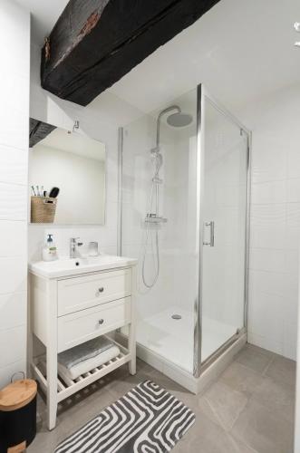 a white bathroom with a shower and a sink at Good vibes à Senlis in Senlis