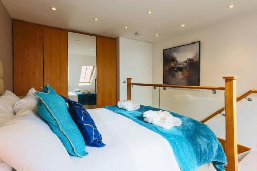 a bedroom with two blue pillows on a bed at Seafront Cottage - The Nook in Cardiff