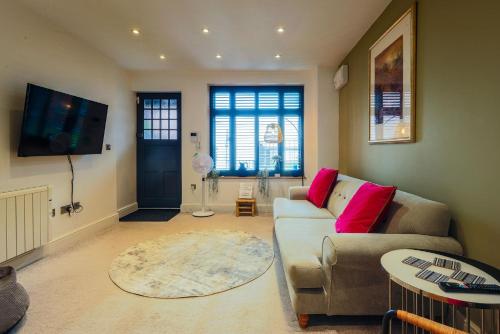 a living room with a couch and a tv at Seafront Cottage - The Nook in Cardiff