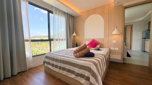 a bedroom with a bed and a large window at 2BR Fantasea condo kamala in Kamala Beach