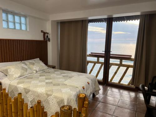 ein Schlafzimmer mit Bett und Meerblick in der Unterkunft Hotel Sunset Chancay in Chancay
