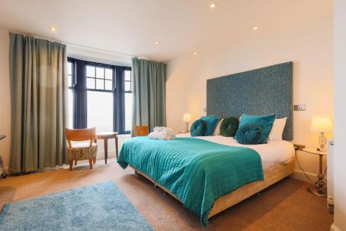 a bedroom with a large bed with a green blanket at Beachcliff Rooms & Apartments in Cardiff