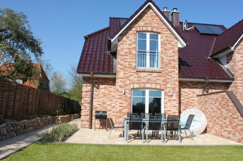 a brick house with a table and chairs on a patio at Ferienhaus Oberhüs - Das Familien-Ferienhaus an der Ostsee in Scharbeutz
