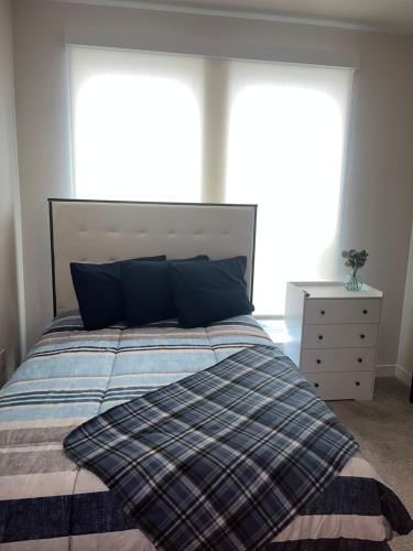 a bedroom with a bed with blue pillows and a window at Arthouse in Houston