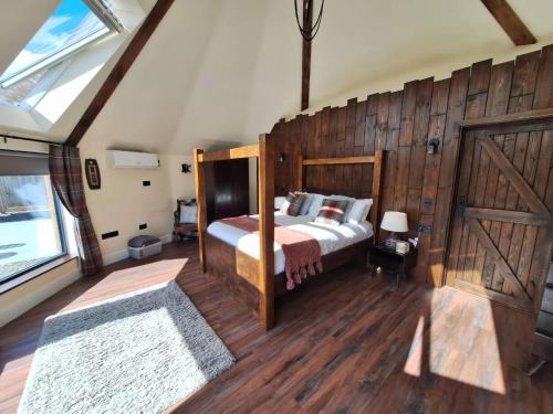 a bedroom with a bed with a wooden wall at Y Cwlwm - The Celtic Knot in Lampeter