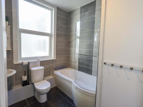 a bathroom with a tub and a toilet and a sink at St Johns View in Keswick