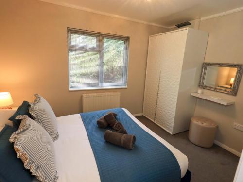 a bedroom with a large bed with two towels on it at Evermore Lodge in Windermere