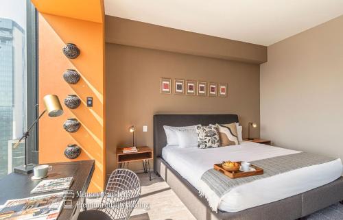 a bedroom with a bed with a wooden tray on it at Casa Magenta by Kukun in Mexico City
