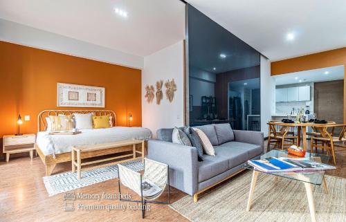 a living room with a bed and a couch at Casa Magenta by Kukun in Mexico City