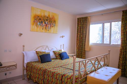 a bedroom with a bed and a window at Leet Dorian HOTEL in Libreville