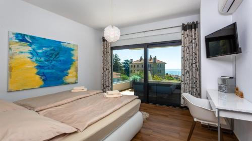 a bedroom with a bed and a desk and a window at Villa Angello in Matulji