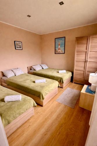 two beds in a room with wooden floors at Apartamenty Ster Darłówko in Darlowko